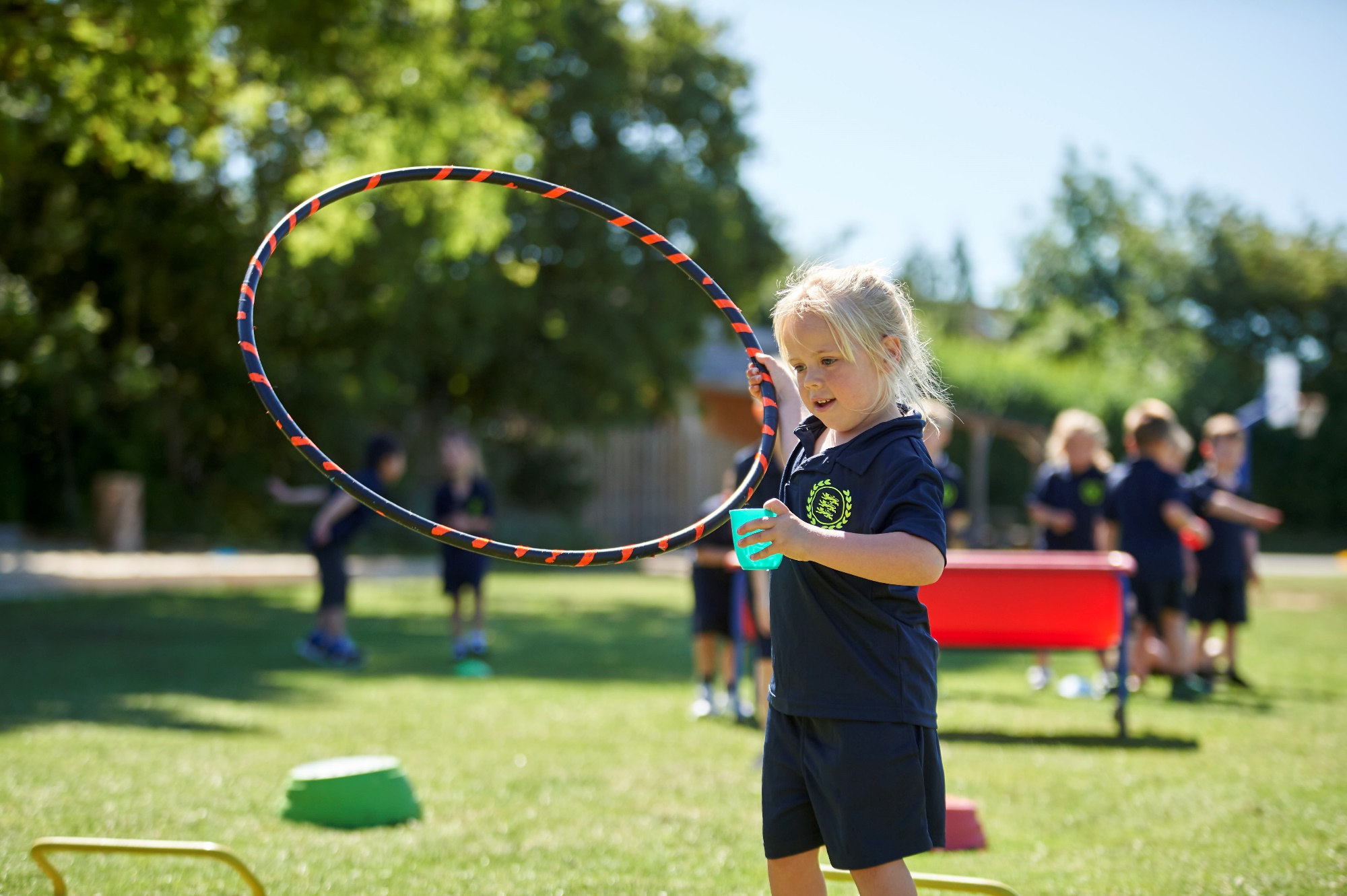 Image of a child playing with a hoop during a PE lesson